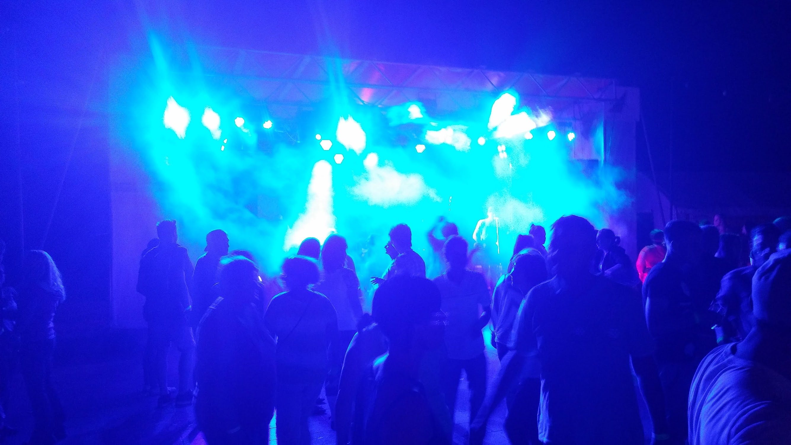 Tanzfläche unter buntem Licht – Menschen feiern und bewegen sich zur Musik